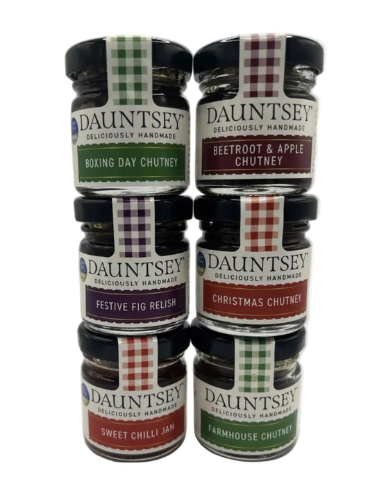 Six jars of Dauntsey Handmade chutney and jam arranged in two stacks of three on a white background. The jars feature black lids and colorful labels in green, red, purple, and white, showing flavors including Boxing Day Chutney, Beetroot & Apple Chutney, Festive Fig Relish, Christmas Chutney, Sweet Chilli Jam, and Farmhouse Chutney.